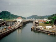 The imposing locks and serene waters of the Panama Canal stretch towards the horizon, a marvel of engineering that connects the Atlantic and Pacific Ocean and a crucial link in global maritime trade