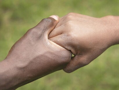 Two hands clasped in solidarity reflect the essential unity African youth must embrace to reclaim the continent's future