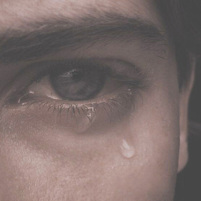 A solitary eye glistens with tears, silently conveying a depth of emotion