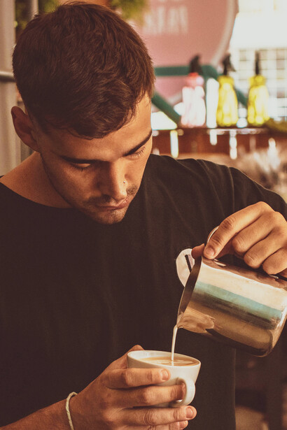 Barista terminando diseño de arte latte. Esta tendencia es reconocida como una disciplina en la comunidad cafetera