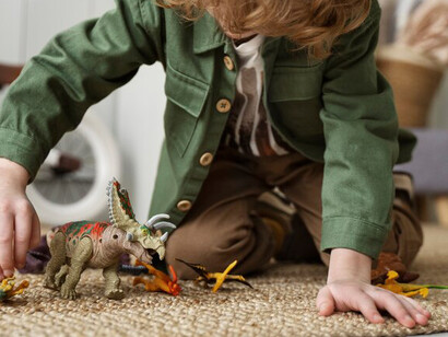 A child having a great time playing on the carpet in the living room