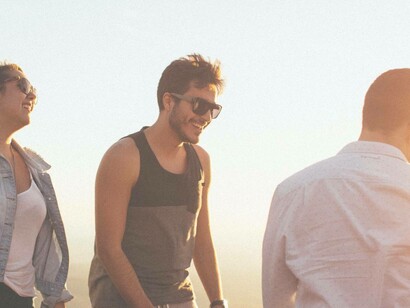 Persone che ridono e parlano tra loro al tramonto