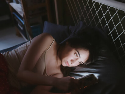 Late at night, a woman scrolls endlessly through her phone, a quiet sign of social media addiction