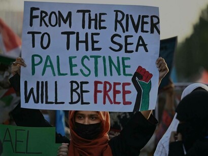 A woman holding up a sign for Palestine to be free