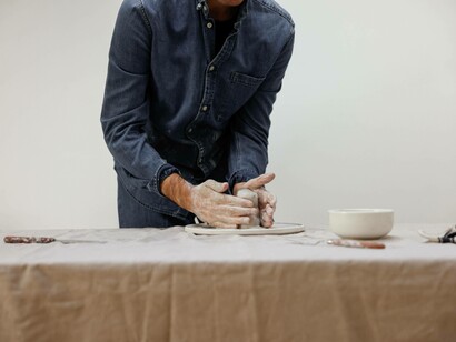 A sculptor carefully caresses and moulding the clay 