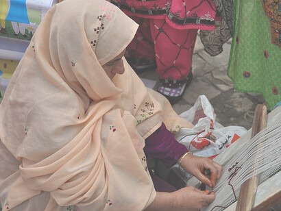 A Pakistani woman working with handmade crafts