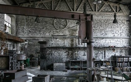 A forgotten factory space with high ceilings and exposed framework, representing the potential for converting industry into habitation