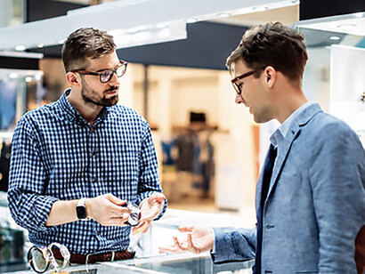 Customer and watch dealer discussing a luxury timepiece in a shopping mall