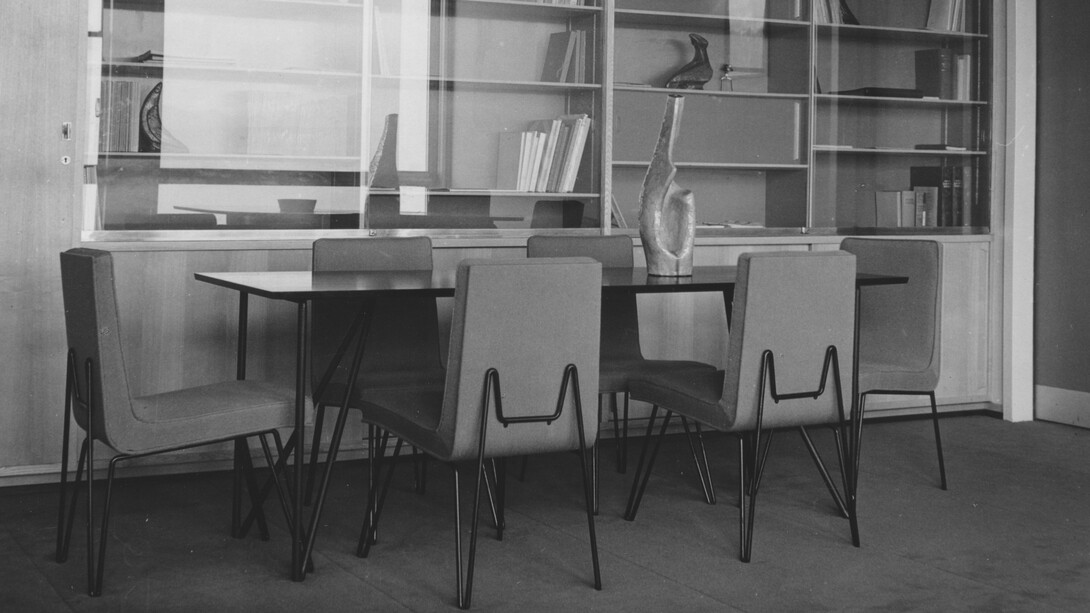 Das Büro des Geschäftsführers mit einem wandmontierten Bücherregal und einem Konferenztisch
sowie den Stühlen mit Metallgestell entworfen vom Architekturbüro Jean Tschumi