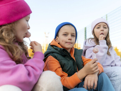 Tres niños comiendo chupetines un día de invierno que hicieron de cimarreros
