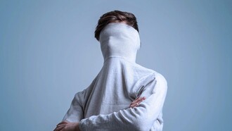 Hombre esconde el rostro en el cuello de su jersey. Identidad es el concepto que cada persona tiene de su individualidad y de su pertenencia a grupos
