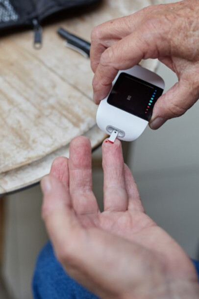 A person checking their blood sugar levels using a glucometer, commonly used for managing Type 1 or Type 2 diabetes