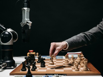 A person playing chess with a robot in a dark room