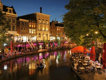 The river meanders through Utrecht, bordered by towering buildings and charming canals that define the city's landscape Netherlands