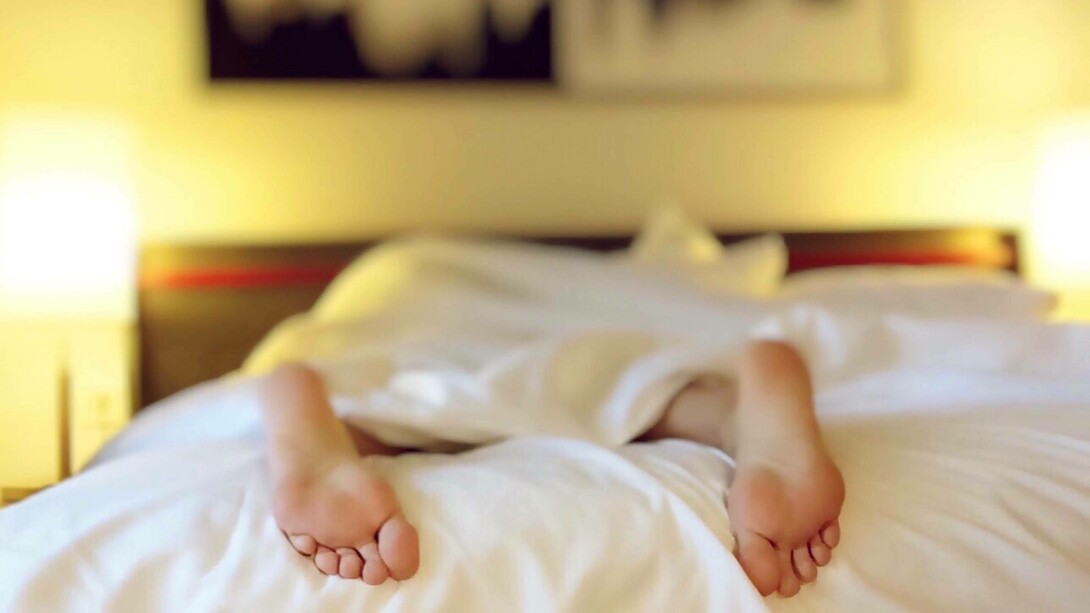 Person laying on their stomach asleep in bed