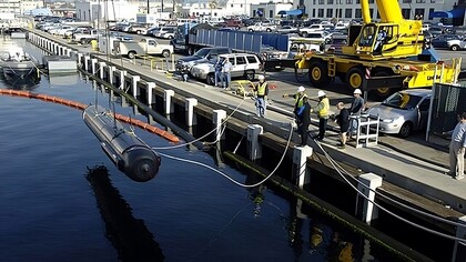 The Seahorse-class Autonomous Underwater Vehicle (AUV) from the applied research laboratory at Penn State University is lowered into the water prior to undergoing launch and recovery testing