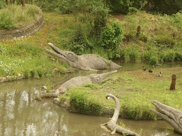 Uma das esculturas de dinossauros do parque londrino evidencia a dimensão que essas criaturas ganharam na cultura popular. Extintos há milhões de anos, os dinossauros não foram uma etapa destinada a ser substituída pelo ser humano, mas parte de uma história evolutiva marcada por sobrevivências, transformações e extinções