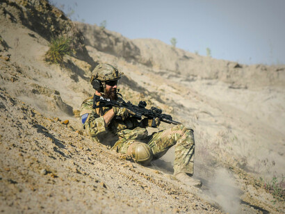 Armed soldier advancing through dust and rubble, symbolising how battlefields replace diplomacy in modern power struggles