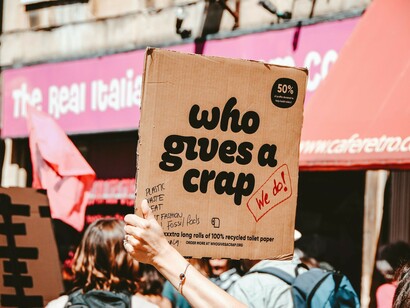 A person holding a "Who Gives A Crap" decorative item