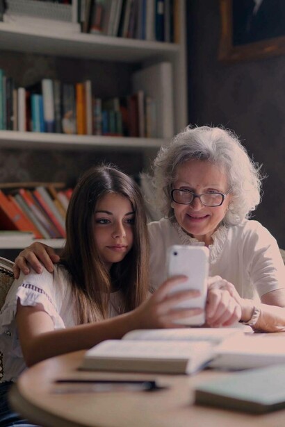 Grandmother learning to use smartphone with grand daughter