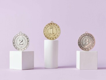 A display of gold, silver, and bronze medals, representing the rigid classification of success and failure