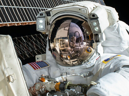 An astronaut floats beside a satellite in space