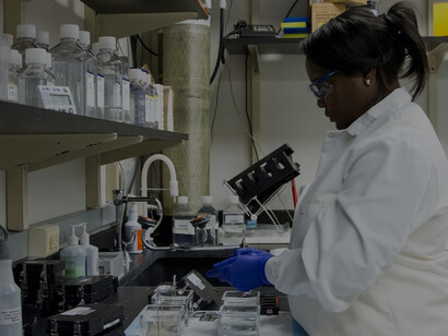 At the Cancer Genomics Research Laboratory, a technician from the National Cancer Institute's Division of Cancer Epidemiology and Genetics (DCEG) carefully washes arrays employed in genome-wide association studies (GWAS)