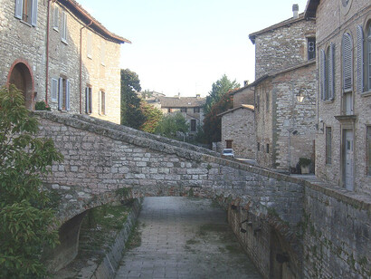 Gubbio, Italia. Analizza come la vicinanza ad Assisi e la spiritualità francescana hanno influenzato Pietro Ubaldi, portandolo a dedicarsi alla ricerca di una pace spirituale universale