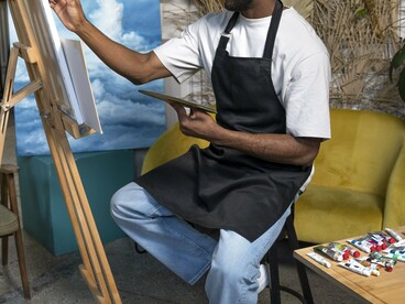 A painter immersed in his craft within a modern studio, symbolising the spirit of African art across changing generations