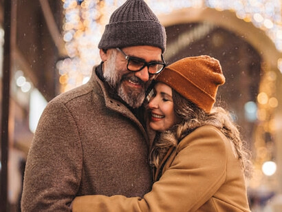 A happy mature couple walking together through the city in winter