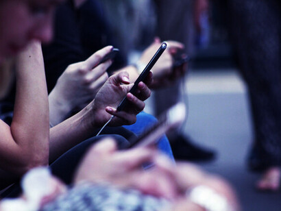 People near each other and using their cell phones; we've designed a world where we emulate conditions that we believe are beneficial, yet in reality, we become