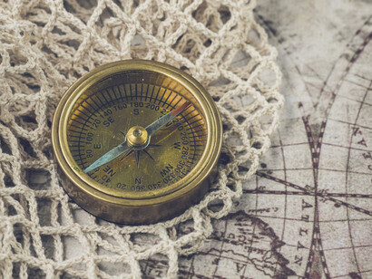 An antique compass resting on a weathered map, representing the geopolitical direction that has shaped Russia's ambitions for centuries