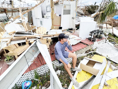 A man sits in the remains of his home in Florida after Hurricane Ian destroyed it