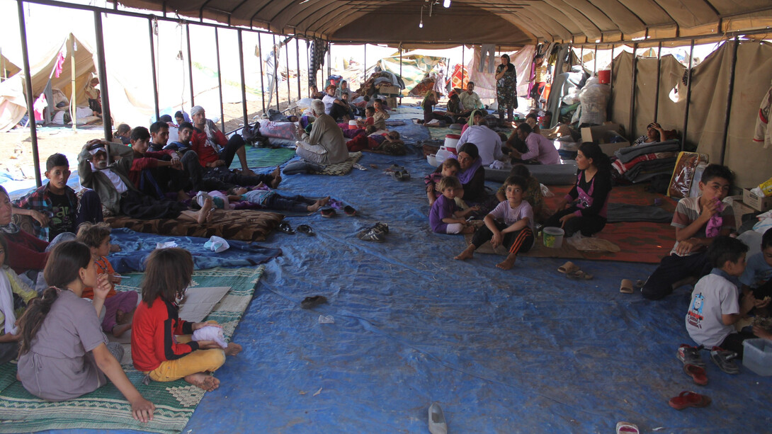 Des réfugiés yézidis ayant fui l’État islamique à travers les montagnes du Sinjar reçoivent une aide humanitaire de l’International Rescue Committee au camp de Newroz, en Syrie, en août 2014