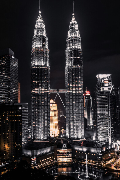 A captivating night view of the Petronas Towers, Kuala Lumpur, Malaysia, showcasing their architectural brilliance and the vibrant cityscape below