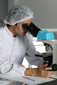 Scienziato al microscopio