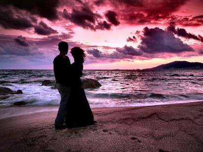 Una pareja en la playa al atardecer