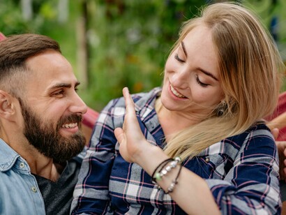 A joyful couple cuddling on a hammock in nature, sharing a moment of love and togetherness