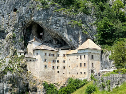 In Slovenia’s Postojna region, Predjama Castle rises dramatically from a cliff, showcasing centuries of history