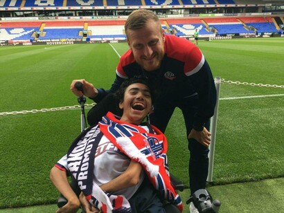 A disabled football fan, Morgan Parry, is treated to meeting one of his footballing heroes on the pitch side at Adams Park - Ground 92