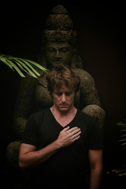In quiet contemplation, a solitary figure stands before a weathered statue, reflecting on the search for inner clarity beyond distraction and noise