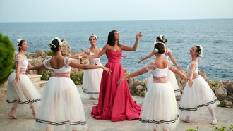 Tamara Radjenovic (center) singing while being surrounded by ballet dancers