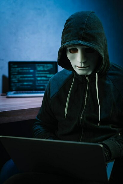A hacker using a laptop underscores the growing concerns surrounding data privacy and the pervasive nature of data collection in the digital age