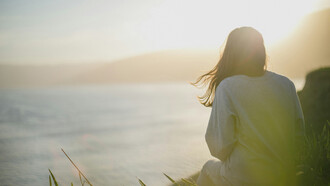 A woman by the seashore, connecting with everything around her
