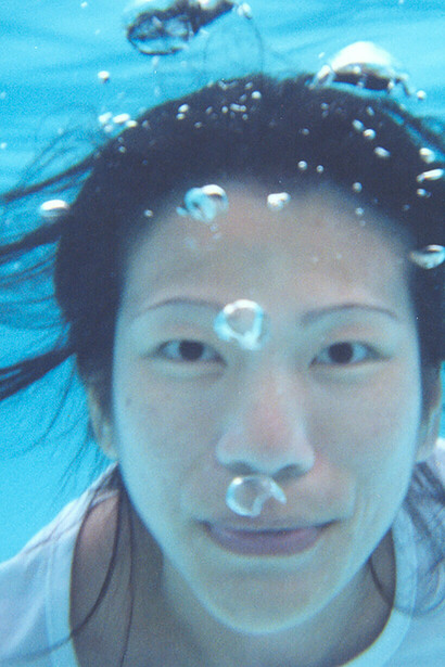 Underwater. Her long black hair waves in the wind, like the arms of castaways, raised to the sky before being engulfed by the Mediterranean © Kim Chi Pho