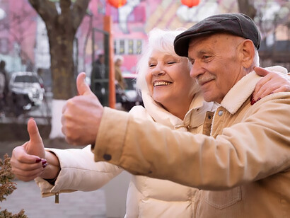 Elderly individuals in a medium shot, expressing approval with thumbs up gestures
