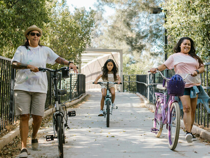 A family cycles through a green urban park, showcasing sustainable city living