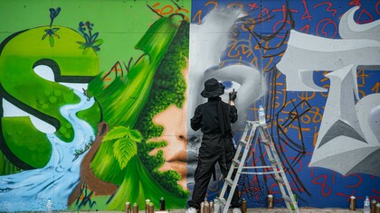 An artist creating graffiti on a wall