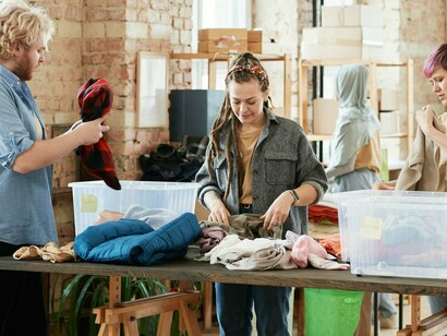 Mulher trabalha em loja de roupas de segunda mão. Um dos desafios mais relevantes da moda sustentável é a necessidade de educar os consumidores e promover uma cultura de transparência. A sustentabilidade não se limita à etiqueta de uma peça de roupa — trata-se de um ciclo completo que começa na origem dos materiais e termina no destino final da peça