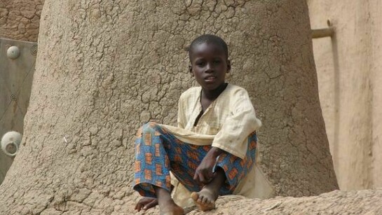 Un bambino sul tetto della sua casa in Mali. Foto di Giovanni Sacchetti